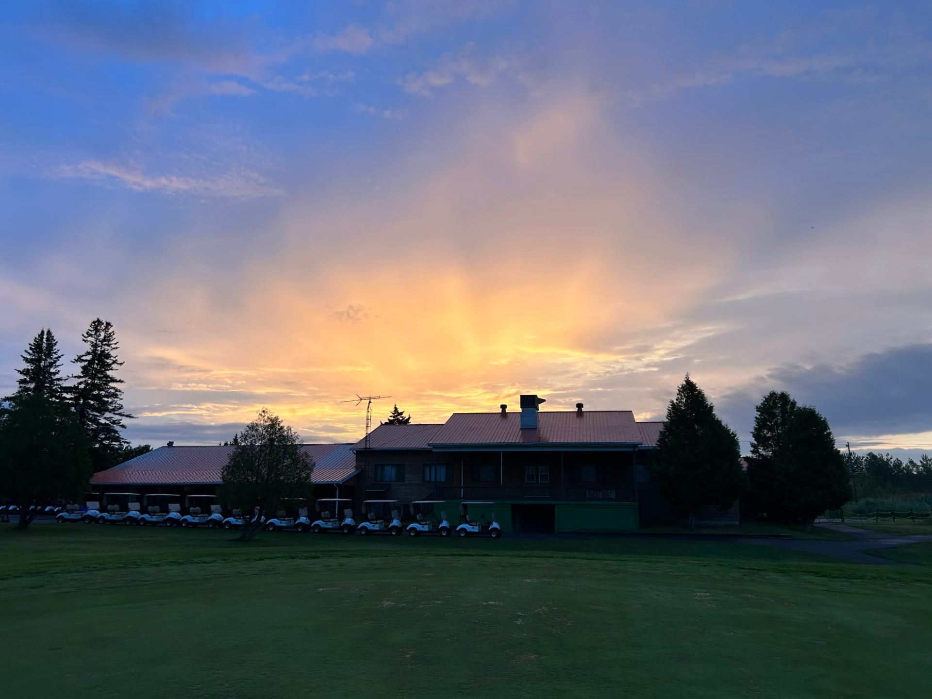 Dramatic golden sunset behind the clubhouse