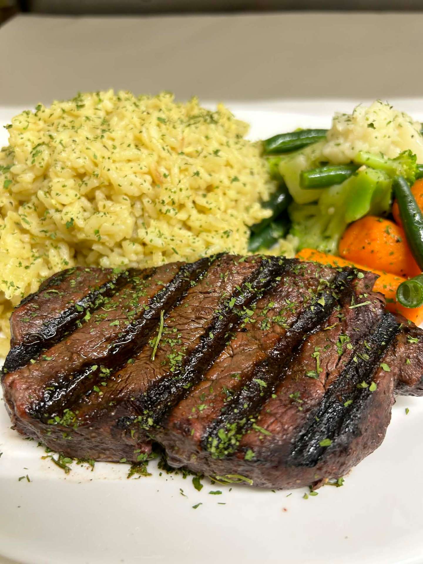 Grilled steak with rice pilaf and vegetables